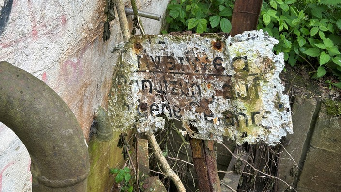 Verrostetes Schild mit der Aufschrift "Privatweg Benutzung auf eigene Gefahr"