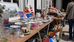 Flohmarktstand mit verschiedenen Porzellan und Glaswaren