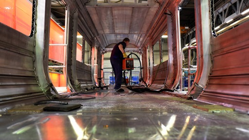 Arbeiter im noch im Rohbau befindlichen Innenraum eines Zugwaggons im Siemens Mobility Werk in Krefeld