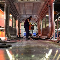 Arbeiter im noch im Rohbau befindlichen Innenraum eines Zugwaggons im Siemens Mobility Werk in Krefeld