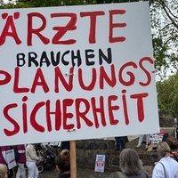 Ärzte demonstrieren in Neuss mit Plakaten.