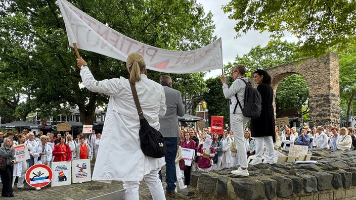 Ärzte demonstrieren in Neuss mit Plakaten.