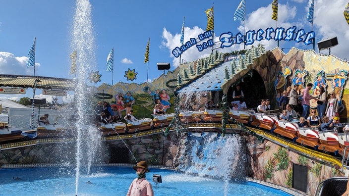 Achterbahn mit einem Wasserbecken und Bergkulisse