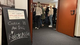 Menschen stehen an Kinokasse an