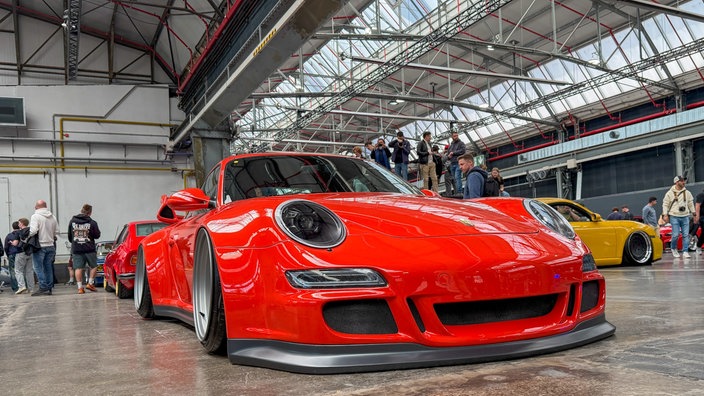 Ein rotes, extrem tiefergelegtes Auto der Marke Porsche