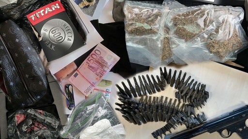 Die Ermittler stellten eine hohe Summe Bargeld, Waffen sowie weitere Gegenstände sicher.