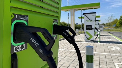 Mehrere Ladesäulen für Elektroautos, an denen Kabel hängen