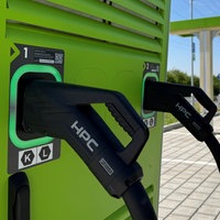 Mehrere Ladesäulen für Elektroautos, an denen Kabel hängen