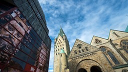Der Dom in Paderborn vor einem blauen, bewölkten Himmel.