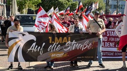 Auf dem Bild sind Menschen zu sehen, die ein Plakat hoch halten.