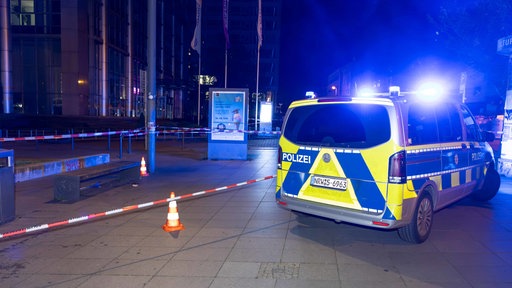 Ein Polizeiauto steht vor einem mit Flatterband abgesperrten Bereich am Essener Hauptbahnhof 