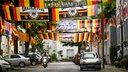 Vespa fährt durch mit Deutschlandflaggen geschmückte Straße