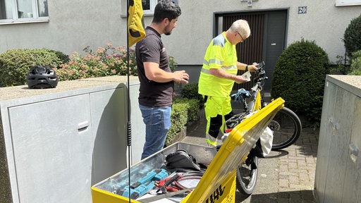 Jürgen Esser vom ADAC und ein ADAC-Mitglied neben dem ADAc-Fahrrad.