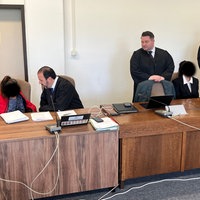 Anwälte, Angeklagte und Übersetzerin im Gerichtssaal