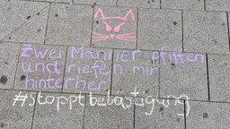 Auf Bordsteinen steht eine Kreidezeichnung zu Catcalling.