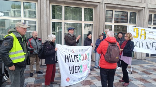 Demonstrierende Menschen stehen vor dem Rathaus in Köln.