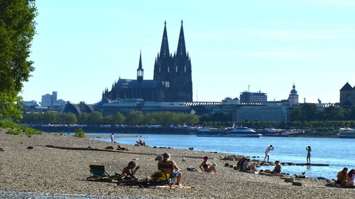 Am Rheinufer in Köln genießen die Menschen das erste Wochenende mit Hochsommertemperaturen