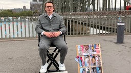 Künstler Andreas Sarow. Im Hintergrund ist die Hohentollernbrücke zu sehen