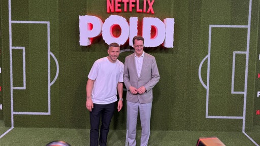 Lukas Podolski und Hendrik Wüst bei der Doku-Premiere "POLDI" im Rhein-Energie-Stadion in Köln