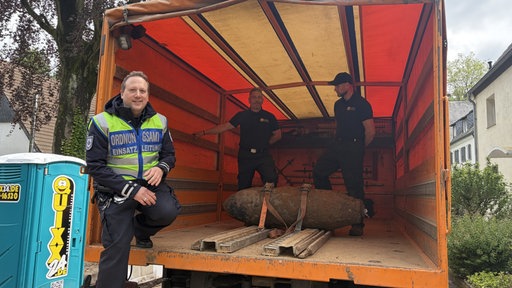 Einsatzkräfte des Ordnungsamtes stehen neben der entschärften Bombe in Lindenthal.