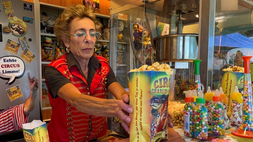 Eine Frau stellt eine Tüte Popcorn auf den Tresen.