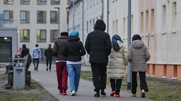 Eine Gruppe von Migranten gehen über das Gelände der Zentralen Erstaufnahmeeinrichtung für Asylbewerber