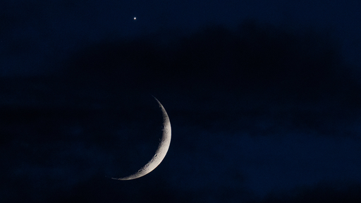 Über dem sichelförmigen Mond ist die Venus zu sehen
