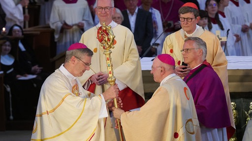 Amtseinführung von Heiner Wilmer als neuen Bischofs von Münster im Dom St. Paulus. Heiner Wilmer (l), neuer Bischof von Münster, nimmt von seinem Vorgänger Felix Genn, der 2025 in den Ruhestand gegangen ist, den Bischofsstab entgegen. 