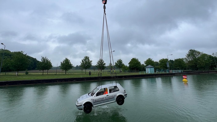 ein Auto an einem Kran über Wasser