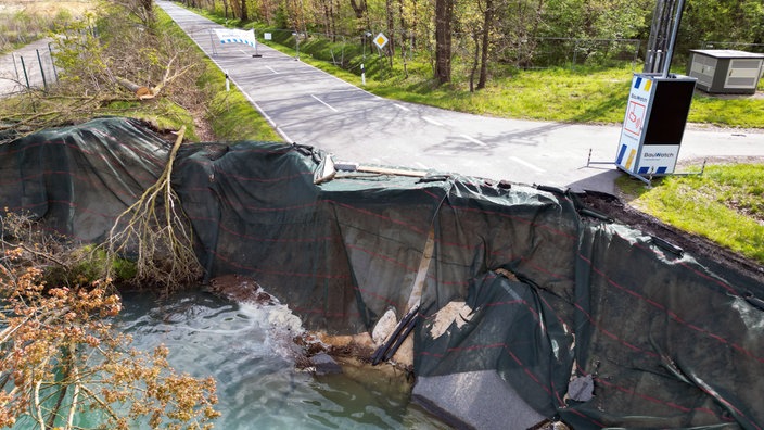 Nahaufnahme von dem Erdrutsch an der Straße. Abgedeckt mit einer Plane.