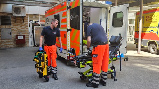 Zwei Männer beladen einen Rettungswagen