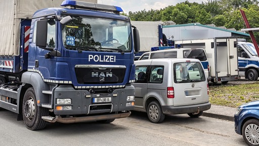 Bundespolizei-Einsatz-LKW steht mit anderen Polizei- und normalen Autos auf einem Parkplatz.