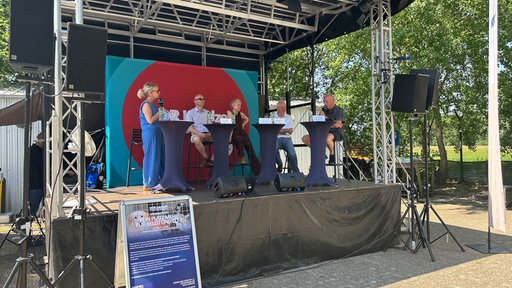 Mehrere Menschen stehen auf einer Bühne