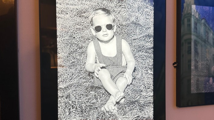 Auf einem Bild ist Udo Lindenberg als Kind mit Sonnenbrille zu sehen.