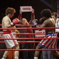 Rocky und sein Gegner Creed stehen im Boxring und werden von Fans angefeuert.