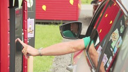 Eine Person tippt aus einem Auto heraus auf einen Bildschirm