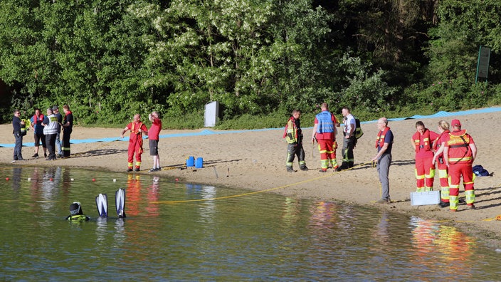 Rettungstaucher und andere Rettungsmenschen am und im Feldmarksee in Sassenberg.