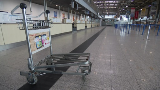 Leerer Gepäckwagen in leerer Halle am Flughafen Weeze