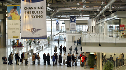 Menschen stehen Schlange in einem Flughafen-Terminal