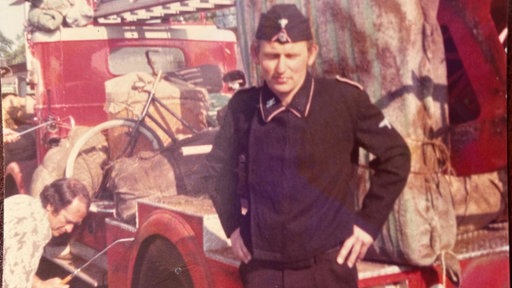 Fredde Förch in einer schwarzen Uniform am Set im Jahr 1976