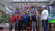 Kinder des Dorfes empfangen die Jury in der Grundschule.