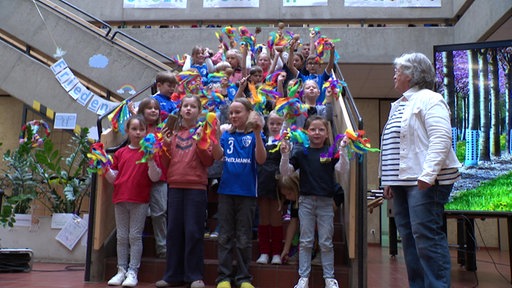 Kinder des Dorfes empfangen die Jury in der Grundschule.