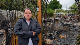 Frau vor einem ausgebrannten Campingplatz