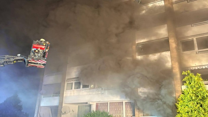 Die Feuerwehr ist bei einem Brand in einem Wohnhaus mit Kran im Einsatz.