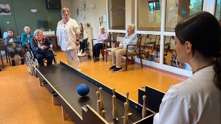 Die beiden Pflegehilfskräfte Mariola Galwas und Melisa Trumic spielen mit den Bewohnern im Pflegezentrum Bowling.