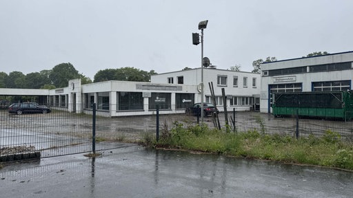 Das ehemalige Autohaus als mögliche Flüchtlingsunterkunft. Dunkle Wolken und Regen.