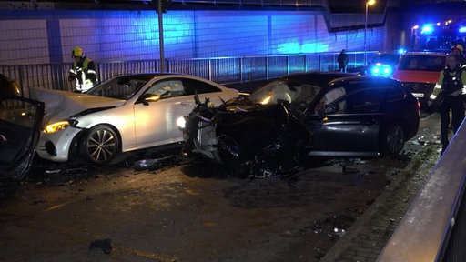 Zerstörte Autos stehen auf der Straße in einer Bahn-Unterführung