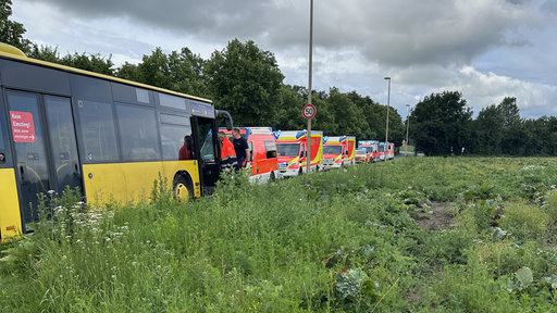 Der gelbe Schulbus steht am Straßenrand. Daneben sind einige Fahrzeuge des Rettungsdienstes zu sehen.
