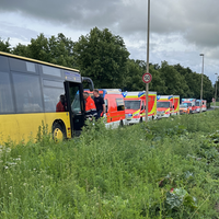 Der gelbe Schulbus steht am Straßenrand. Daneben sind einige Fahrzeuge des Rettungsdienstes zu sehen.