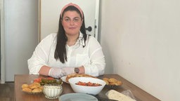 Maha an einem mit Speisen gedeckten Tisch während des Opferfestes